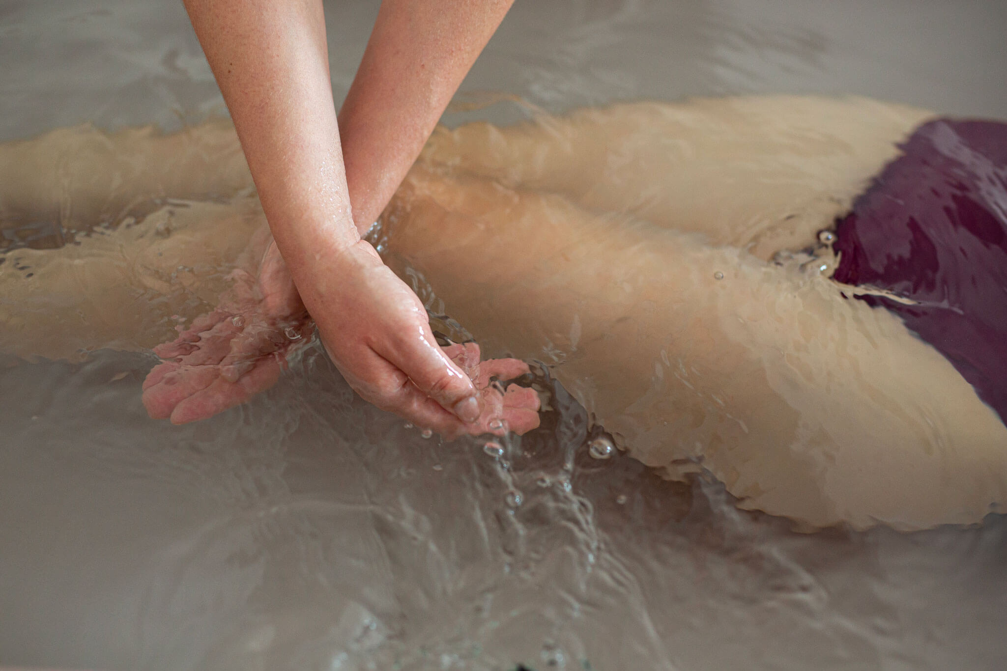 Hands giving a massage in a bath.
